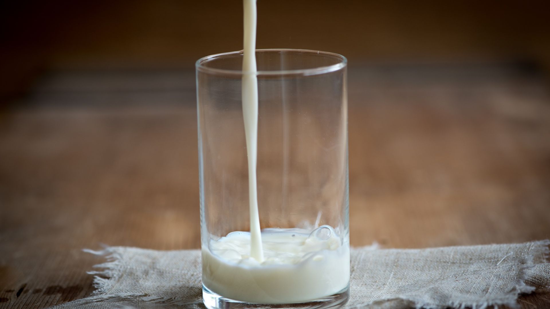 牛乳をコップに入れている画像